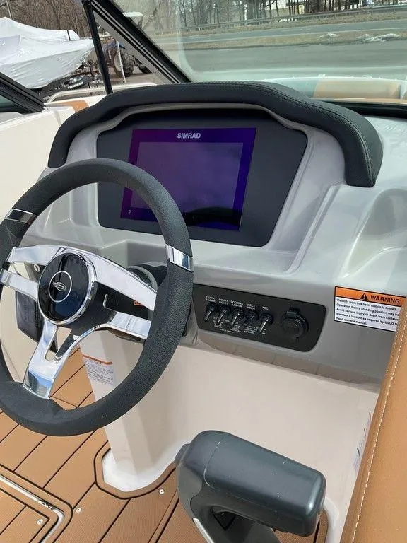 Slide: The Image of 2025 Chaparral 23 SSi boat dashboard with steering wheel and digital display. - 25