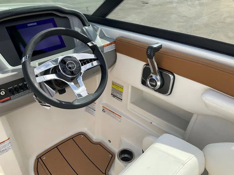 Slide: The Image of Interior of 2025 Chaparral 23 SSi boat, featuring steering wheel and control panel. - 26