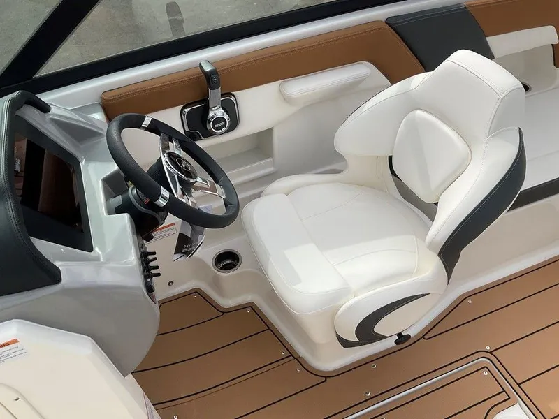 Slide: The Image of 2025 Chaparral 23 SSi boat interior with white captain's seat and modern steering console. - 29