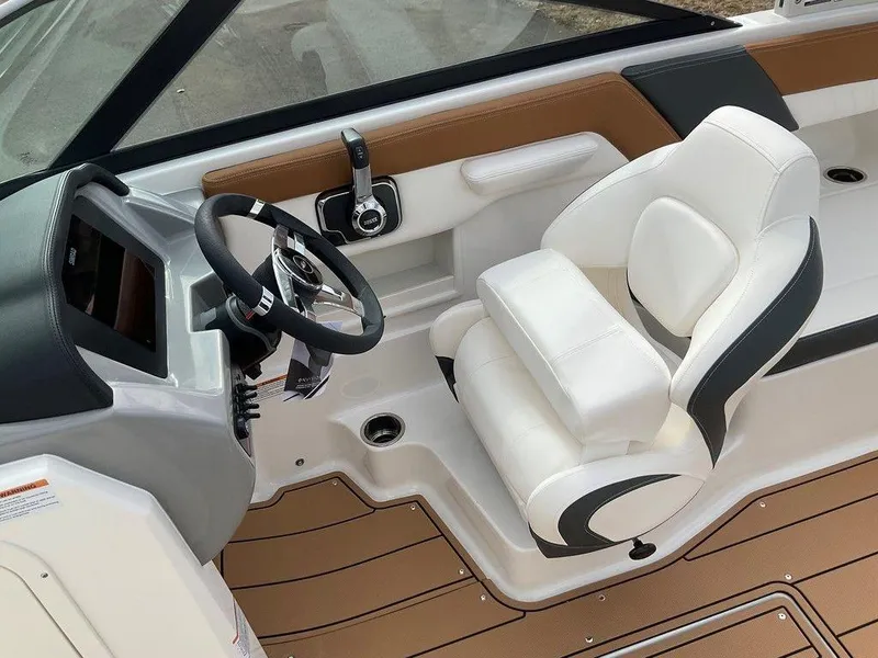 Slide: The Image of 2025 Chaparral 23 SSi boat interior with steering wheel and white captain's seat. - 30