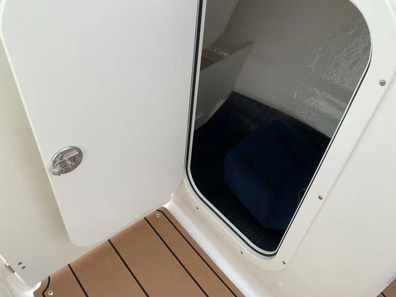 Slide: The Image of 2025 Chaparral 23 SSi boat cabin entrance with open door and teak flooring. - 37