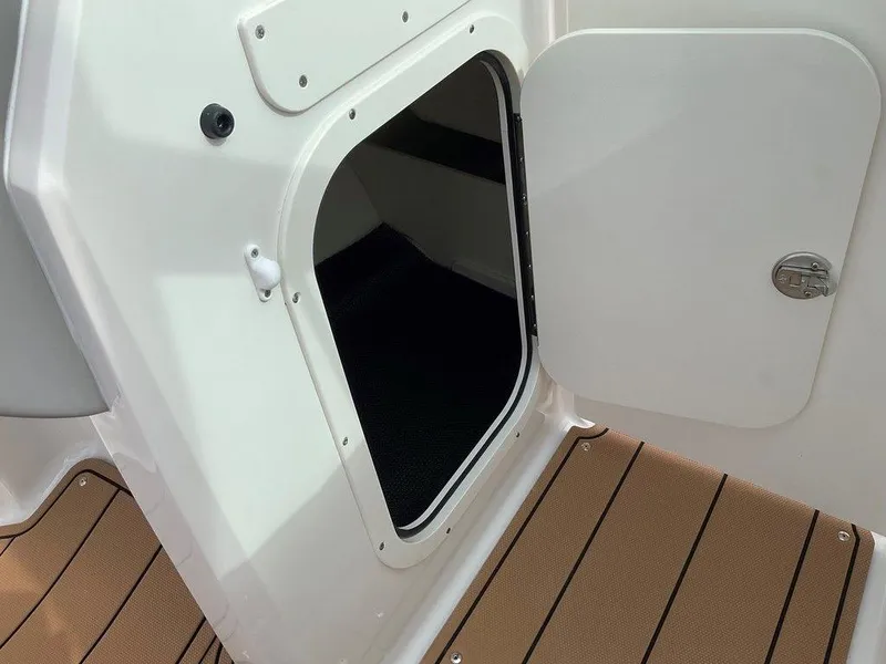 Slide: The Image of 2025 Chaparral 23 SSi boat storage compartment with open hatch and teak flooring. - 38