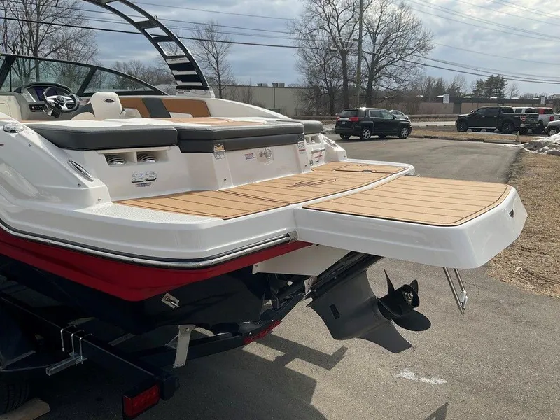 Slide: The Image of 2025 Chaparral 23 SSi boat with extended swim platform, parked outdoors. - 4