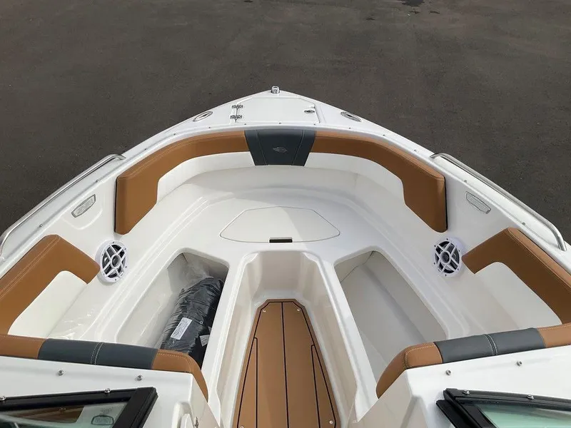 Slide: The Image of 2025 Chaparral 23 SSi boat interior with tan and white seating, speakers, and storage compartments. - 41