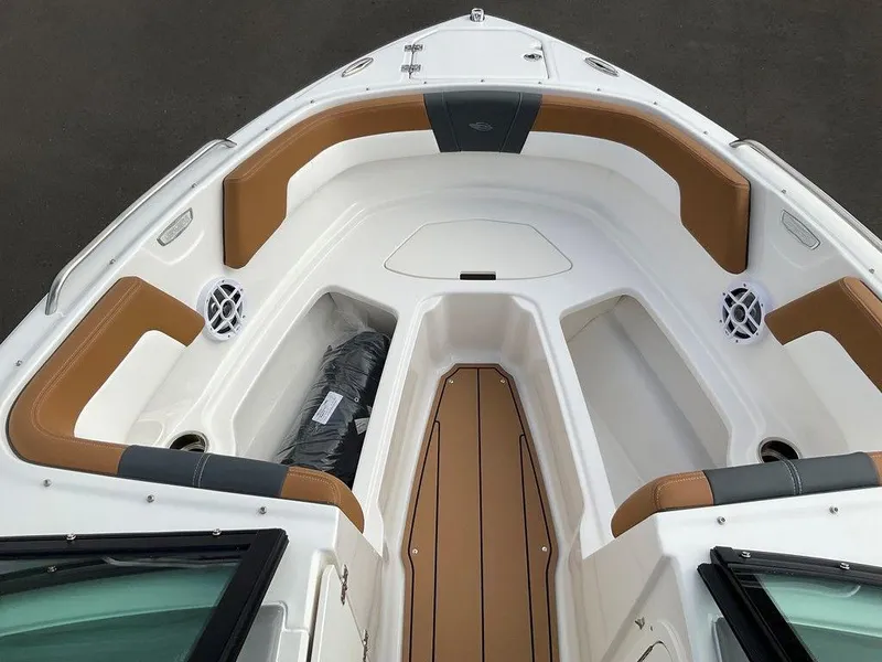 Slide: The Image of 2025 Chaparral 23 SSi boat interior with tan and white seating, featuring storage compartments. - 46