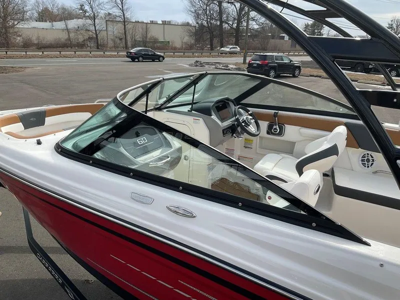 Slide: The Image of 2025 Chaparral 23 SSi boat with sleek red and white design, parked outdoors. - 49