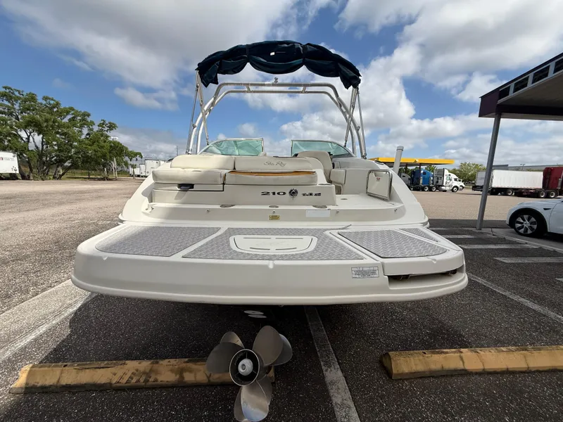 Slide: The Image of 2008 Sea Ray 210 Sundeck boat, rear view, parked outdoors under a cloudy sky. - 22