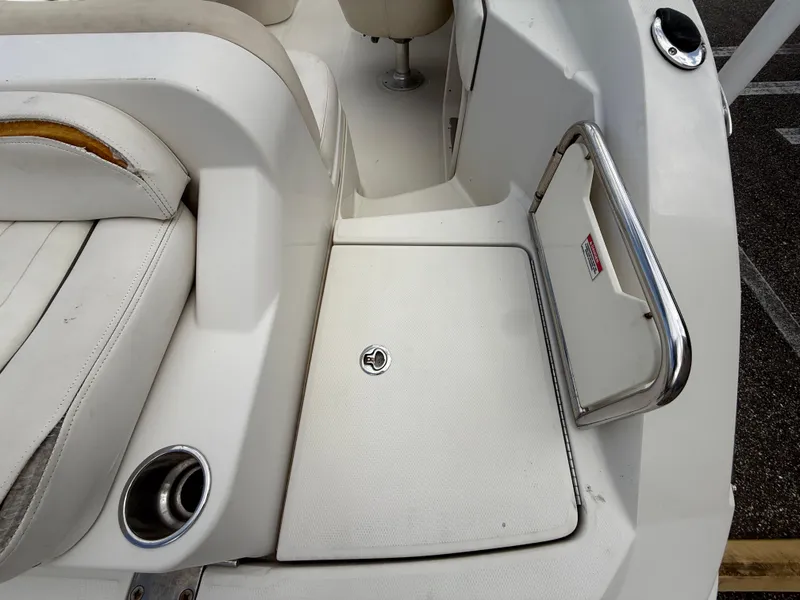 Slide: The Image of 2008 Sea Ray 210 Sundeck interior with white seating and storage compartment. - 35