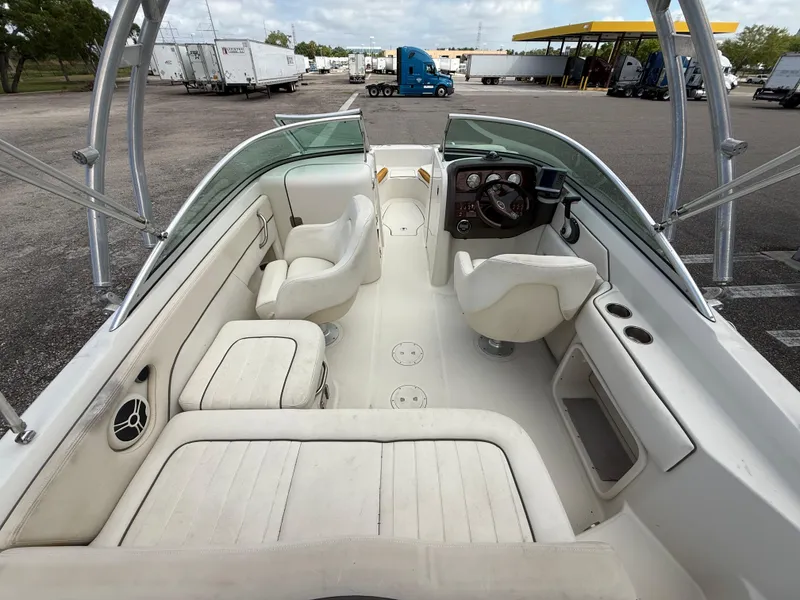 Slide: The Image of 2008 Sea Ray 210 Sundeck interior with seating and steering wheel, parked in a lot. - 37