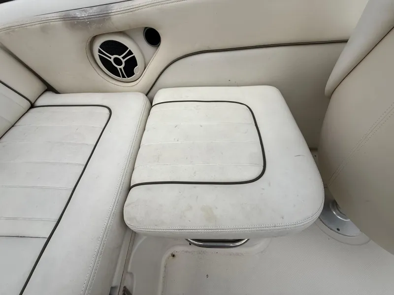 Slide: The Image of 2008 Sea Ray 210 Sundeck interior seating with speaker, white upholstery. - 41