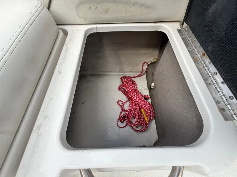 Slide: The Image of Storage compartment in 2008 Sea Ray 210 Sundeck with red rope inside. - 42