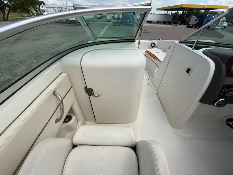 Slide: The Image of 2008 Sea Ray 210 Sundeck interior with white seating and storage compartment. - 48