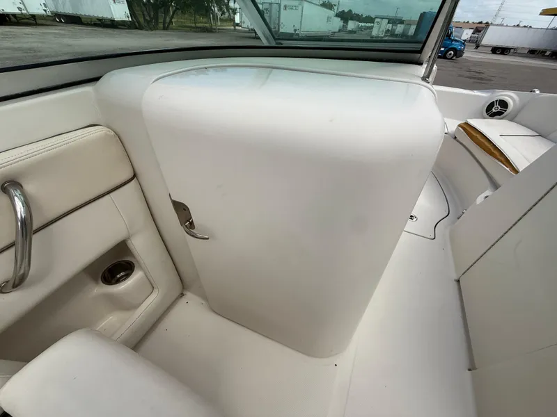 Slide: The Image of Interior of 2008 Sea Ray 210 Sundeck boat, featuring white seating and storage compartment. - 49