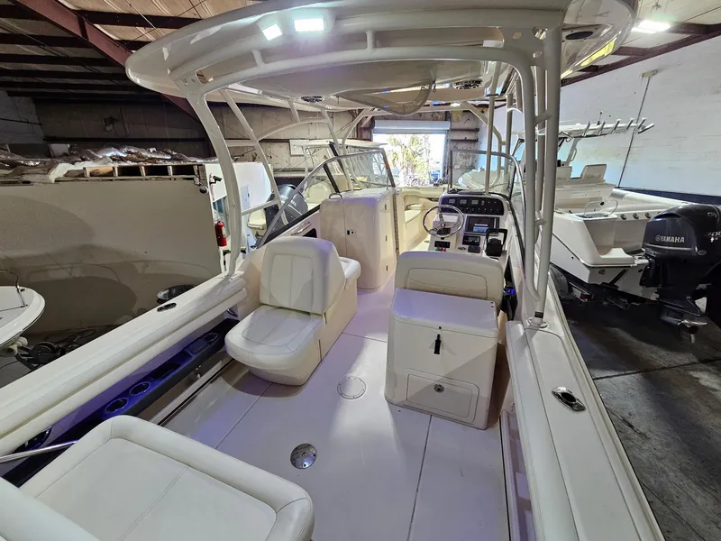 Slide: The Image of 2015 Grady-White Freedom 275 boat interior with seating and controls in a warehouse. - 9