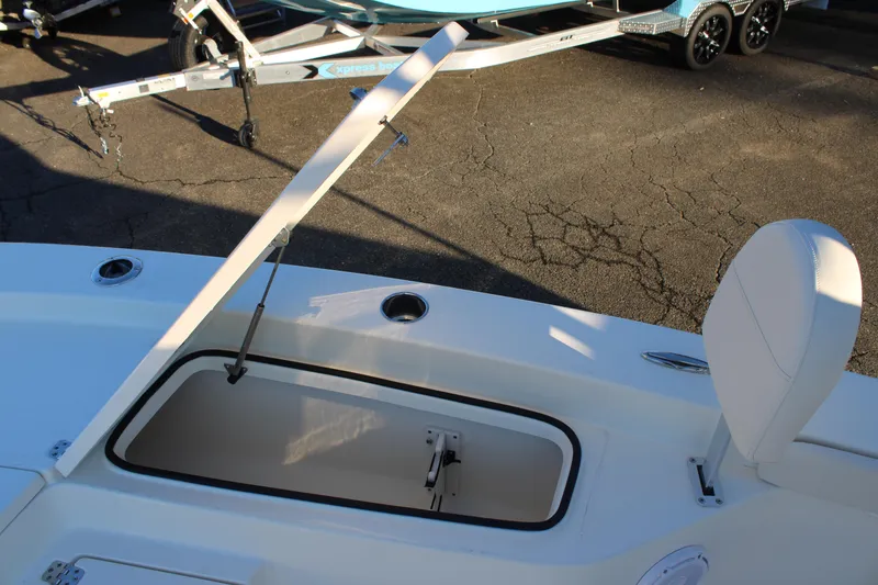 Slide: The Image of Open storage compartment on 2025 Avenger AV26 boat, with trailer in background. - 13