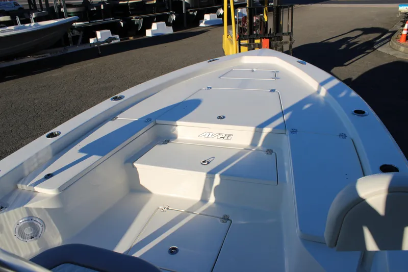 Slide: The Image of 2025 Avenger AV26 boat deck with storage compartments and seating in a marina setting. - 6