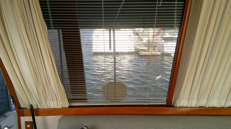 Slide: The Image of Interior view from a 1996 Ocean Alexander 546 Yachtfisher, showcasing window blinds and water outside. - 29