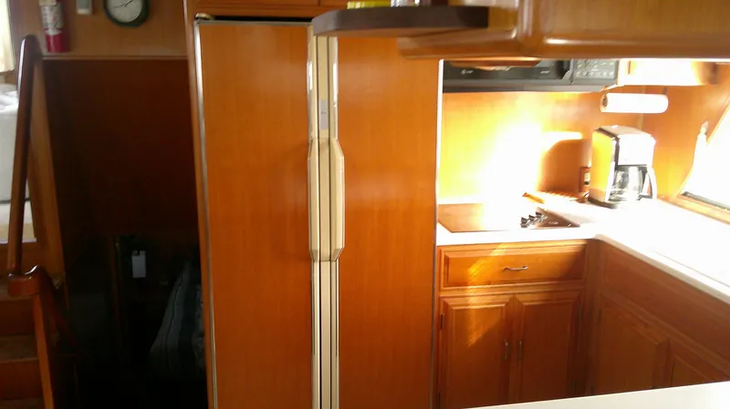 Slide: The Image of Interior of 1996 Ocean Alexander 546 Yachtfisher with wooden cabinetry and kitchen appliances. - 34
