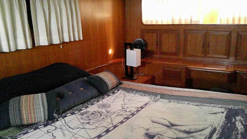 Slide: The Image of Luxurious 1996 Ocean Alexander 546 Yachtfisher cabin with wood paneling and cozy bedding. - 44