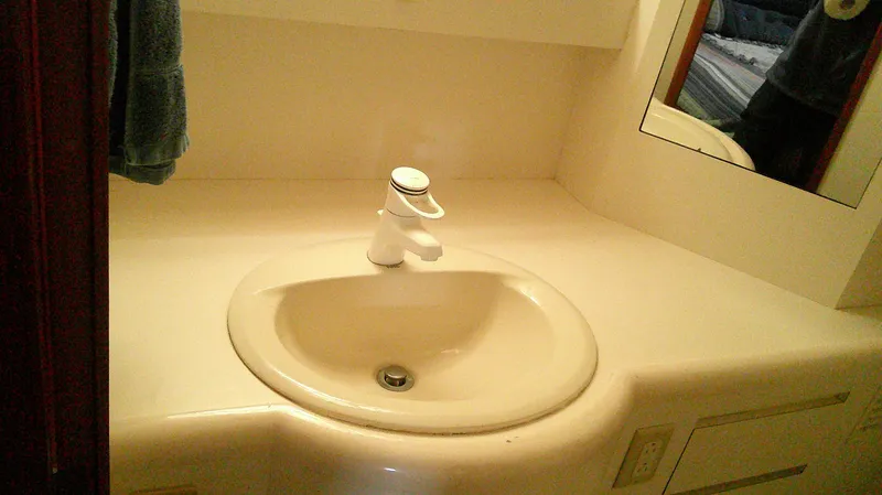 Slide: The Image of Bathroom sink in 1996 Ocean Alexander 546 Yachtfisher, featuring a modern faucet and mirror. - 46