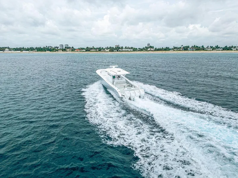 Slide: The Image of 2019 Yellowfin 42 boat cruising on open water near a distant shoreline. - 16