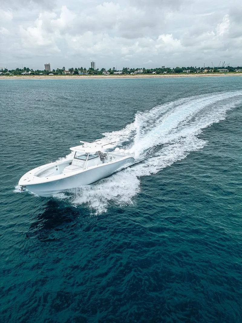 Slide: The Image of 2019 Yellowfin 42 boat cruising on open water near a distant shoreline. - 30