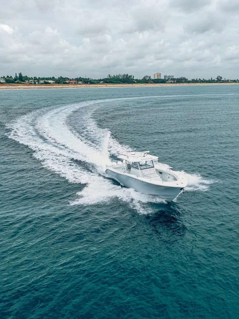 Slide: The Image of 2019 Yellowfin 42 boat cruising on open water near a coastline. - 32