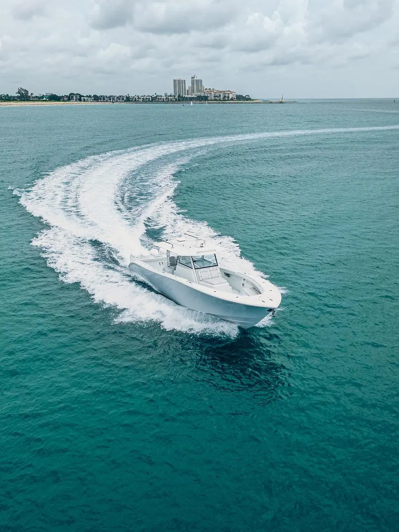 Slide: The Image of 2019 Yellowfin 42 boat cruising on turquoise ocean near coastline. - 8