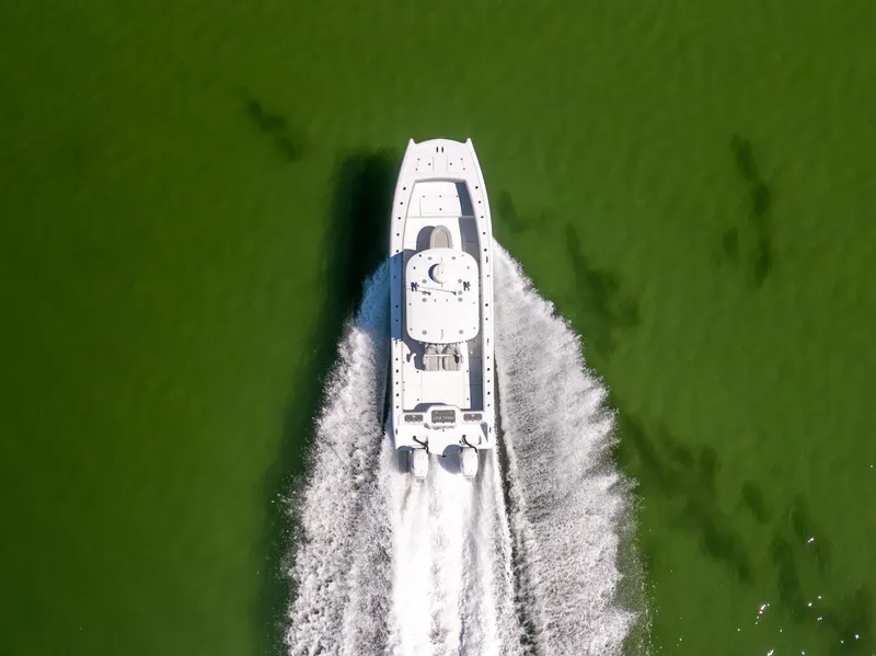 Slide: The Image of Aerial view of 2022 Freeman 34VH boat cruising on green water. - 12