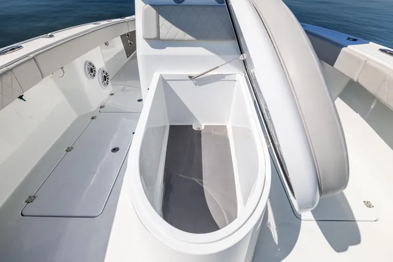 Slide: The Image of 2022 Freeman 34VH boat interior with open storage compartment, white seating, and speakers. - 46