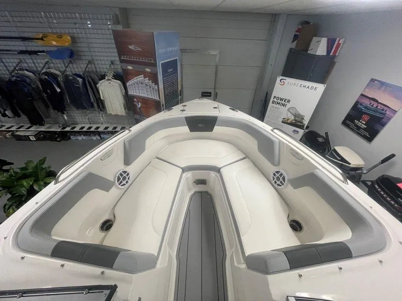 Slide: The Image of 2025 Chaparral 23 SSi boat interior with spacious seating and modern design in showroom. - 14