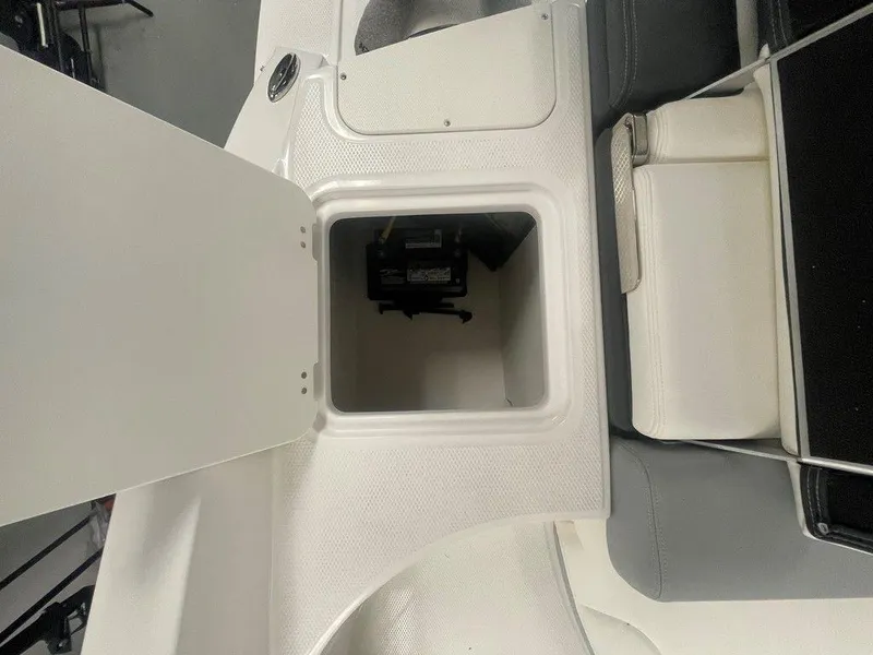 Slide: The Image of 2025 Chaparral 23 SSi boat storage compartment with open hatch, showcasing interior space. - 19