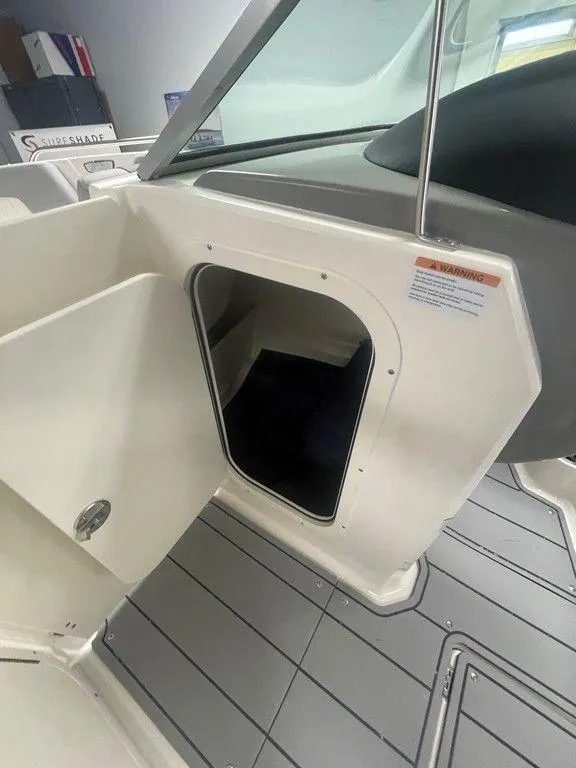 Slide: The Image of 2025 Chaparral 23 SSi boat interior storage compartment with open door, showcasing sleek design. - 22