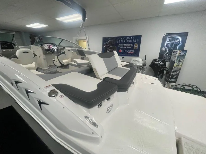Slide: The Image of 2025 Chaparral 23 SSi boat interior with plush seating in showroom. - 26