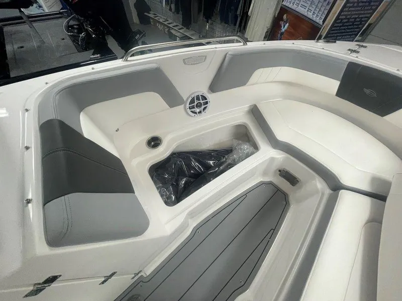 Slide: The Image of 2025 Chaparral 23 SSi boat interior with gray and white seating and storage area. - 32