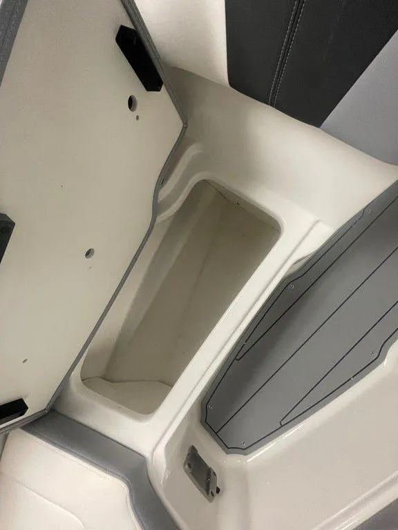 Slide: The Image of 2025 Chaparral 23 SSi boat storage compartment with open lid, showcasing interior space. - 33