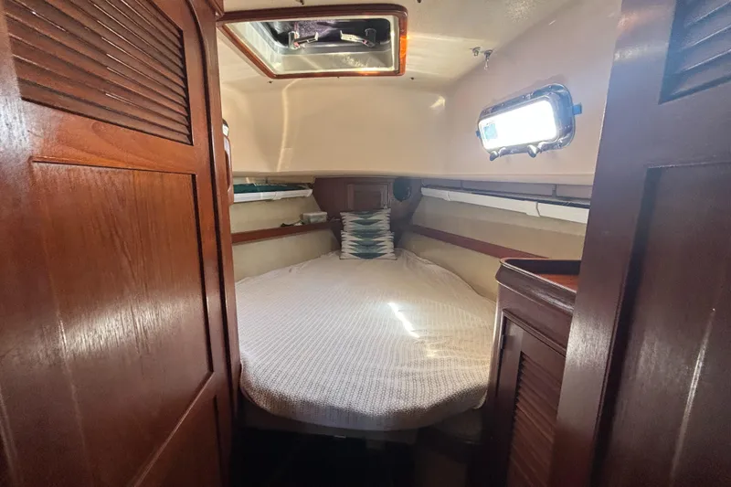 Slide: The Image of Cozy cabin interior of 1995 Island Packet 37 sailboat with wooden finishes and a bed. - 10