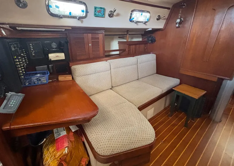 Slide: The Image of 1995 Island Packet 37 interior with wooden table, cushioned seating, and nautical decor. - 13
