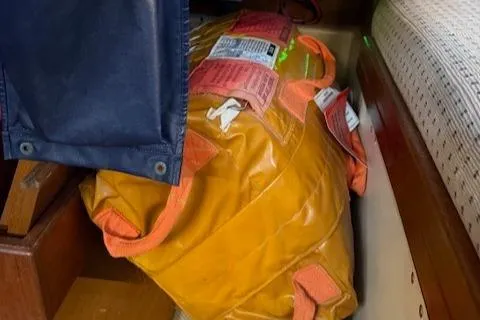 Slide: The Image of Orange safety equipment stored on a 1995 Island Packet 37 sailboat. - 19