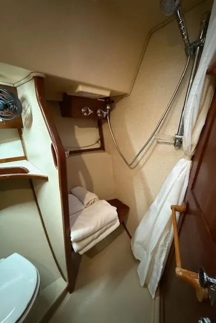 Slide: The Image of 1995 Island Packet 37 yacht bathroom with shower, towels, and wooden accents. - 23