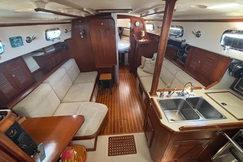 Slide: The Image of Interior of a 1995 Island Packet 37 sailboat with wood finish and cozy seating. - 8