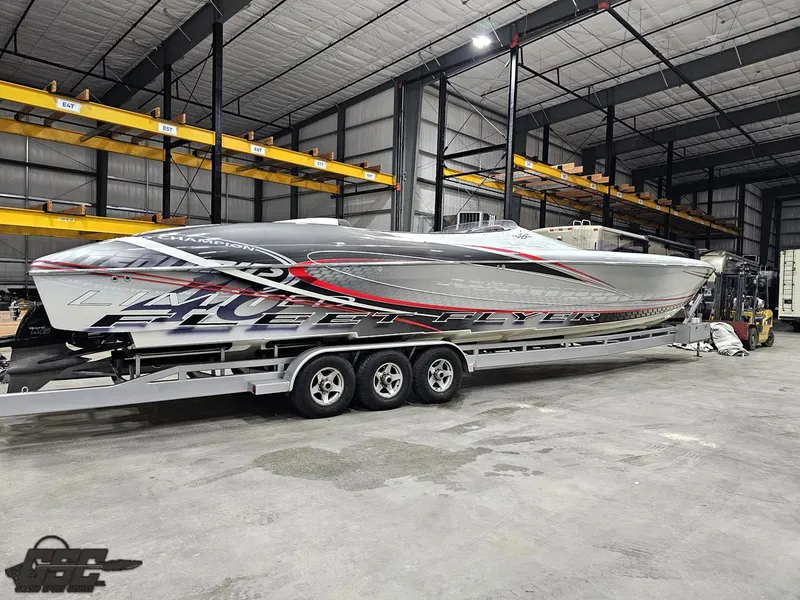Slide: The Image of 2006 Outerlimits 46 Limited speedboat in warehouse, on a triple-axle trailer. - 16