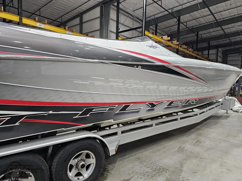 Slide: The Image of 2006 Outerlimits 46 Limited speedboat on trailer in warehouse, sleek design with red and black accents. - 17