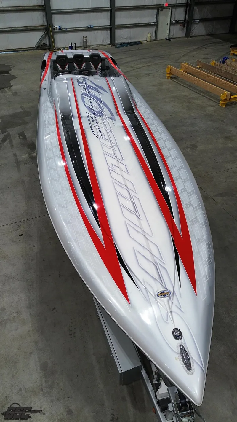 Slide: The Image of 2006 Outerlimits 46 Limited speedboat with sleek red and white design in a garage setting. - 46