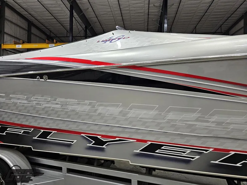 Slide: The Image of 2006 Outerlimits 46 Limited boat with sleek design and bold graphics in a warehouse. - 7