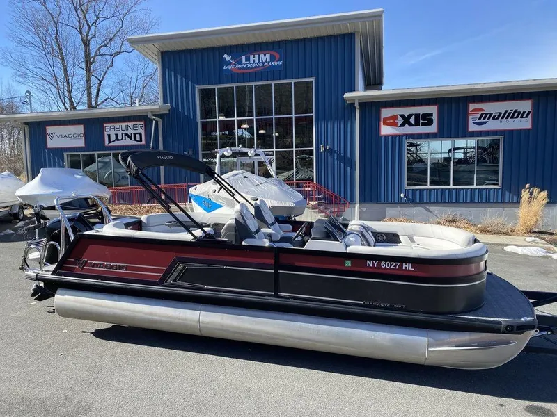 The Image of 2024 Viaggio Diamante D22U Triple pontoon boat parked outside dealership. - 1