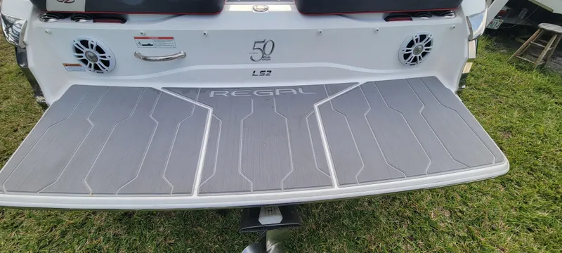 Slide: The Image of 2021 Regal LS2 boat rear deck with speakers and logo on grass. - 14