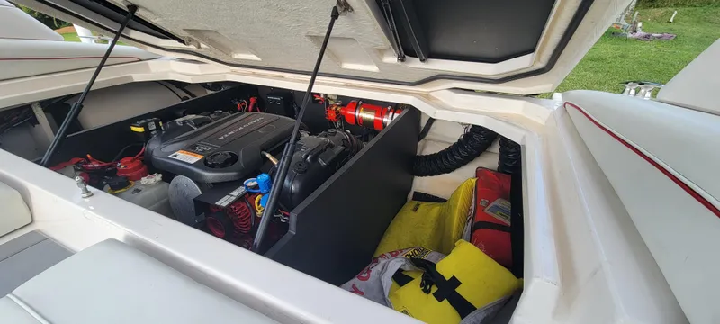 Slide: The Image of Open engine compartment of 2021 Regal LS2 boat, showcasing engine and storage area. - 22