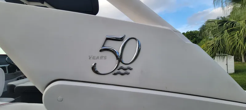 Slide: The Image of 2021 Regal LS2 boat with '50 Years' emblem, white exterior, palm trees in background. - 25