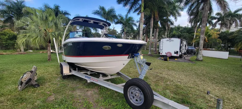 Slide: The Image of 2021 Regal LS2 boat on trailer, surrounded by palm trees in a grassy area. - 3